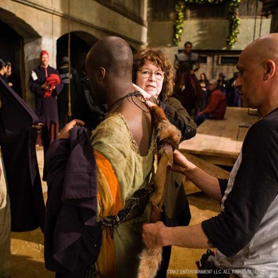 Costume Designer Barbara Darragh adjusts a costume on set